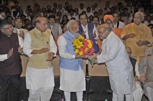 NEW DELHI, MAR 16 (UNI):- Prime Minister Narendra Modi being received with a flower bouquet by BJP National President Amit Shah at the BJP Parliamentary Party meeting at Parliament house library, in New Delhi on Thursday.UNI PHOTO-22U