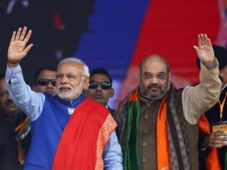 Indian Prime Minister Narendra Modi (L) and Amit Shah, the president of India's ruling Bharatiya Janata Party (BJP), wave to their supporters during a campaign rally ahead of state assembly elections, at Ramlila ground in New Delhi January 10, 2015. REUTERS/Anindito Mukherjee (INDIA - Tags: POLITICS ELECTIONS)