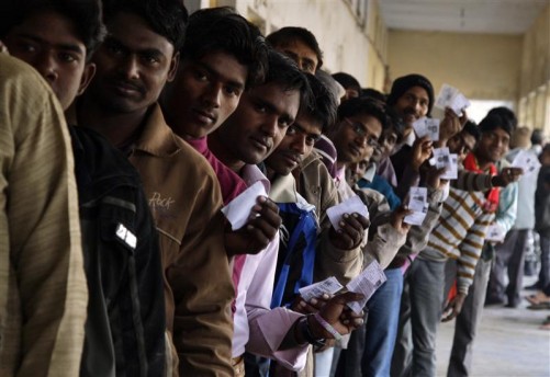 Voters display their voter identity cards as they wait for their turn to cast their ballots at a polling station during the second phase of state assembly elections, in Gorakhpur in the northern Indian state of Uttar Pradesh February 11, 2012. Uttar Pradesh, with 200 million people, stretches southeast from New Delhi, divided along its length by the Ganges River. To avoid violence, voting is staggered over seven days. Results from a total of five state elections are to be announced on March 6. REUTERS/Jitendra Prakash (INDIA - Tags: POLITICS ELECTIONS)